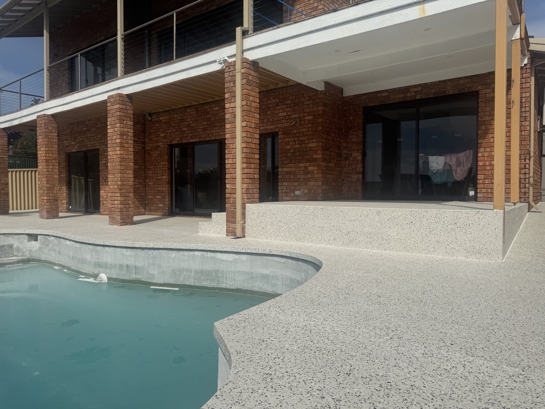 Honed aggregate outdoor living area and pool surround in Carine